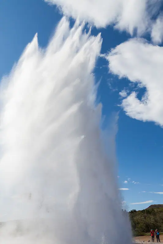 Hot-spring geyser shooting a white column of water skyward