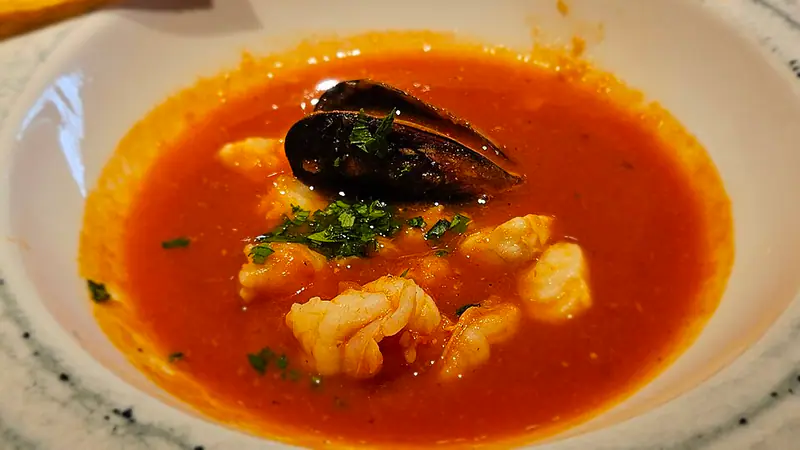 Bowl of red fish stew with mussel and shrimp