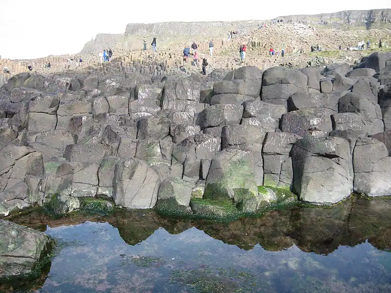 Hexagonal stone columns reflected in a pool