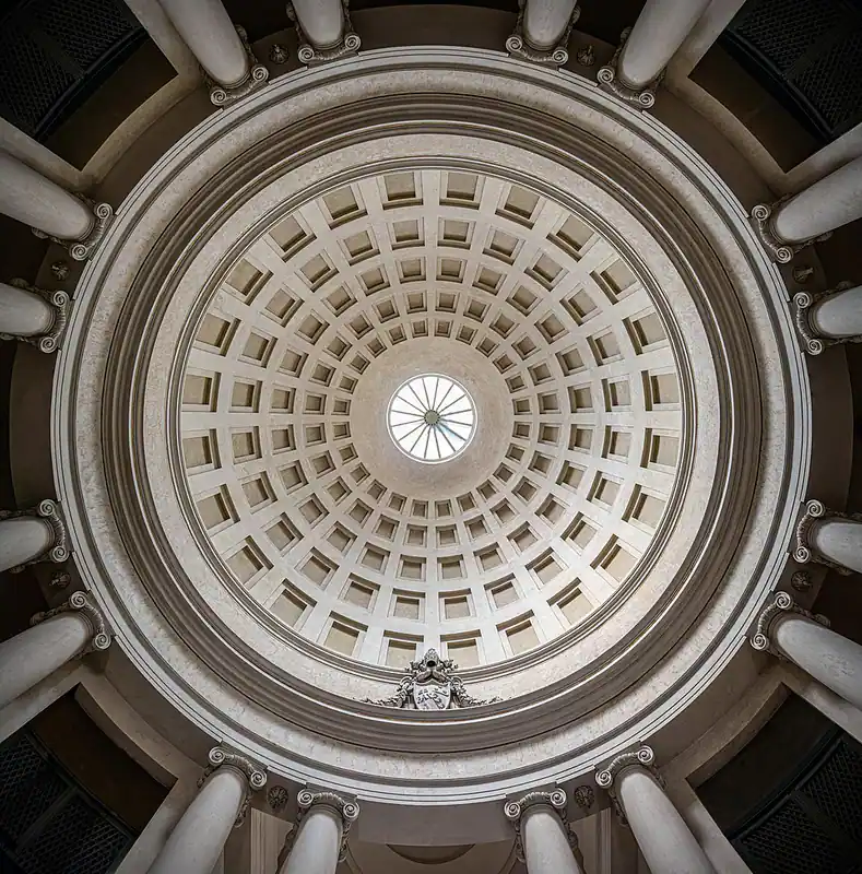 Looking up into a large coffered dome with a round opening